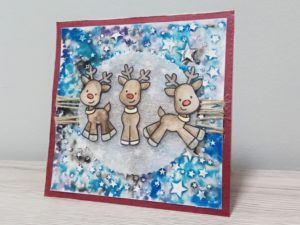 Card natalizia con renne su cielo stellato
