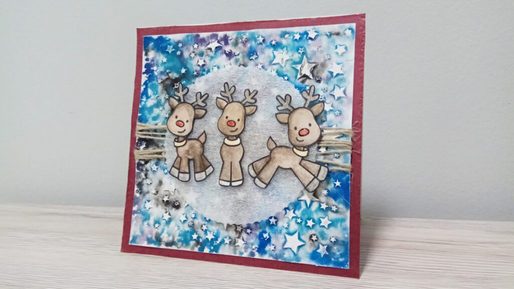 Card natalizia con renne su cielo stellato
