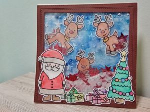 Shaker Card natalizia con Babbo Natale e renne che consegnano i regali